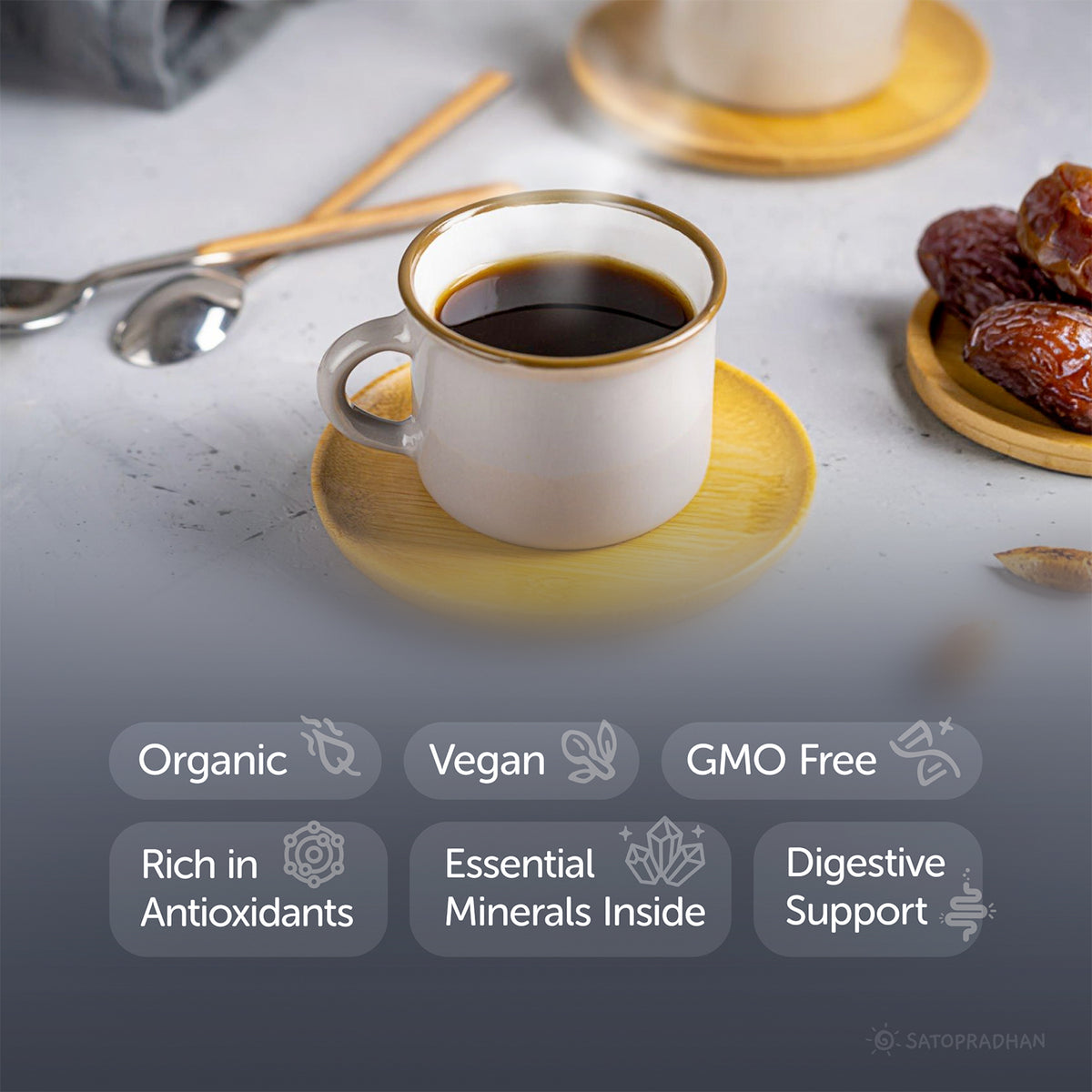 White coffee cup with gold rim on a wooden saucer, surrounded by dates and utensils on a light surface.