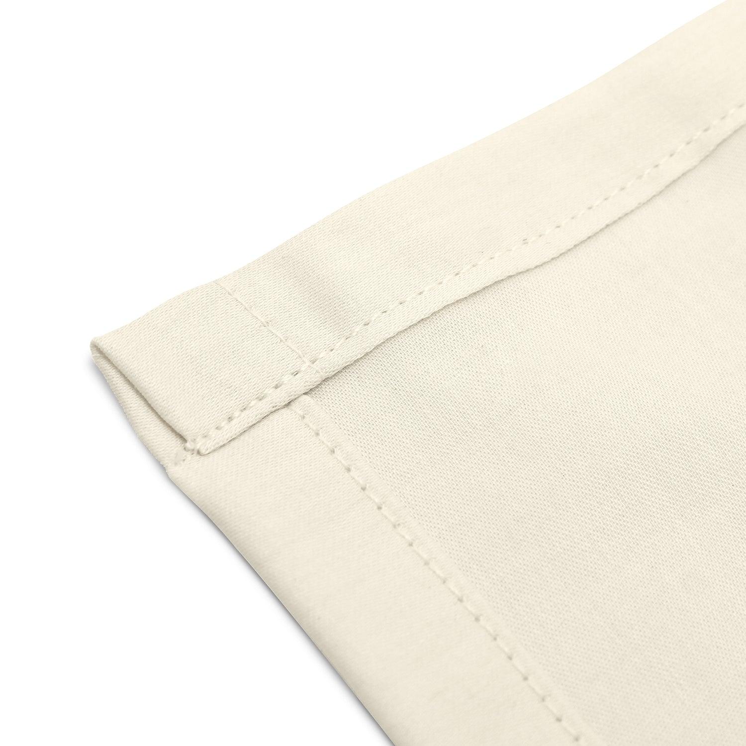 Close-up of neatly stitched corners of an organic cotton handkerchief for women, 12x12 inches, cream white.